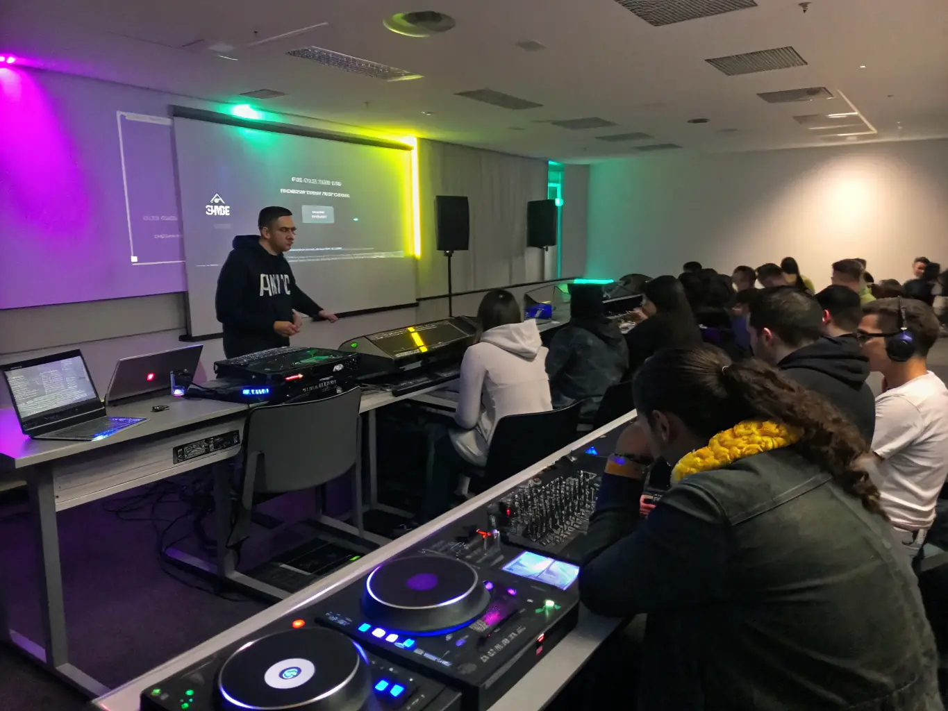 A workshop setting where young people are learning about music production and sound engineering from experienced instructors, highlighting Lion's Crown Sound System's commitment to education.